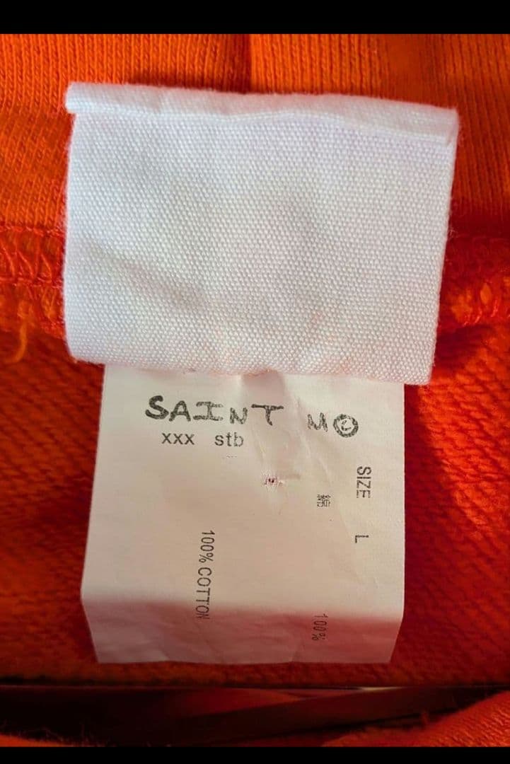 SAINT××××××オレンジ　パーカー。