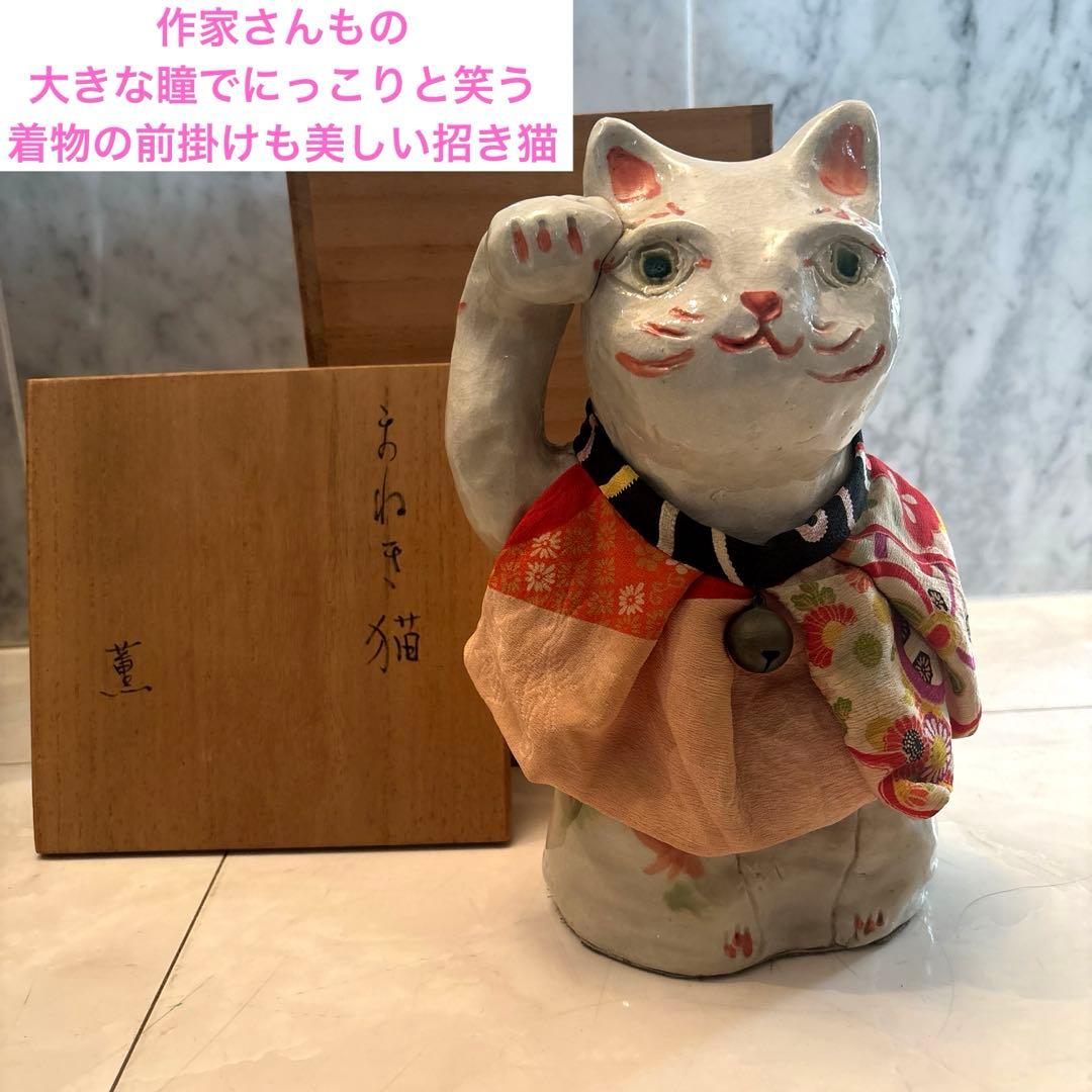 作家さんによる大きな瞳でにっこりと笑う着物の前掛けも美しい招き猫