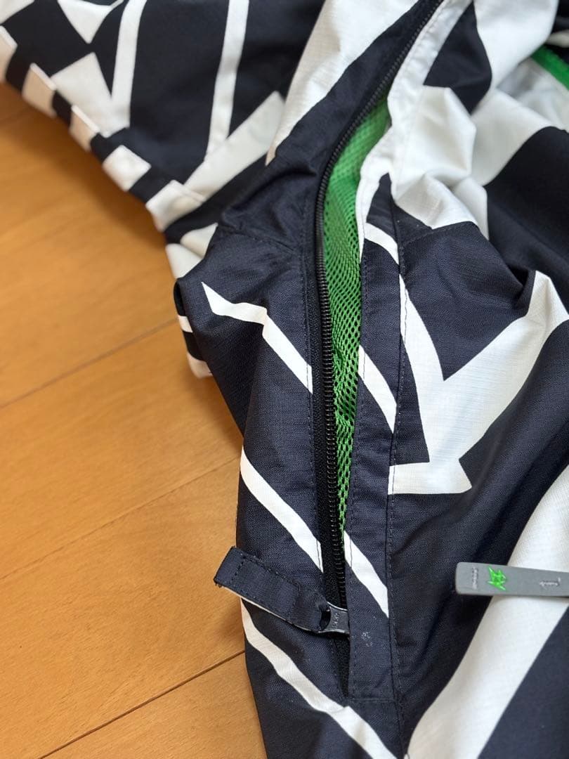 『白と黒の幾何学模様が特徴的なスノーボードウェアのジャケット』