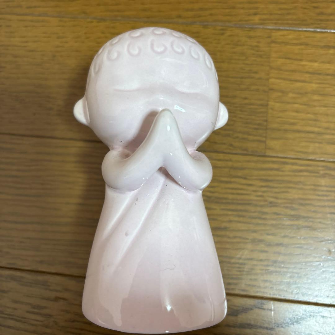 ピンクの陶器製手を合わせた人形